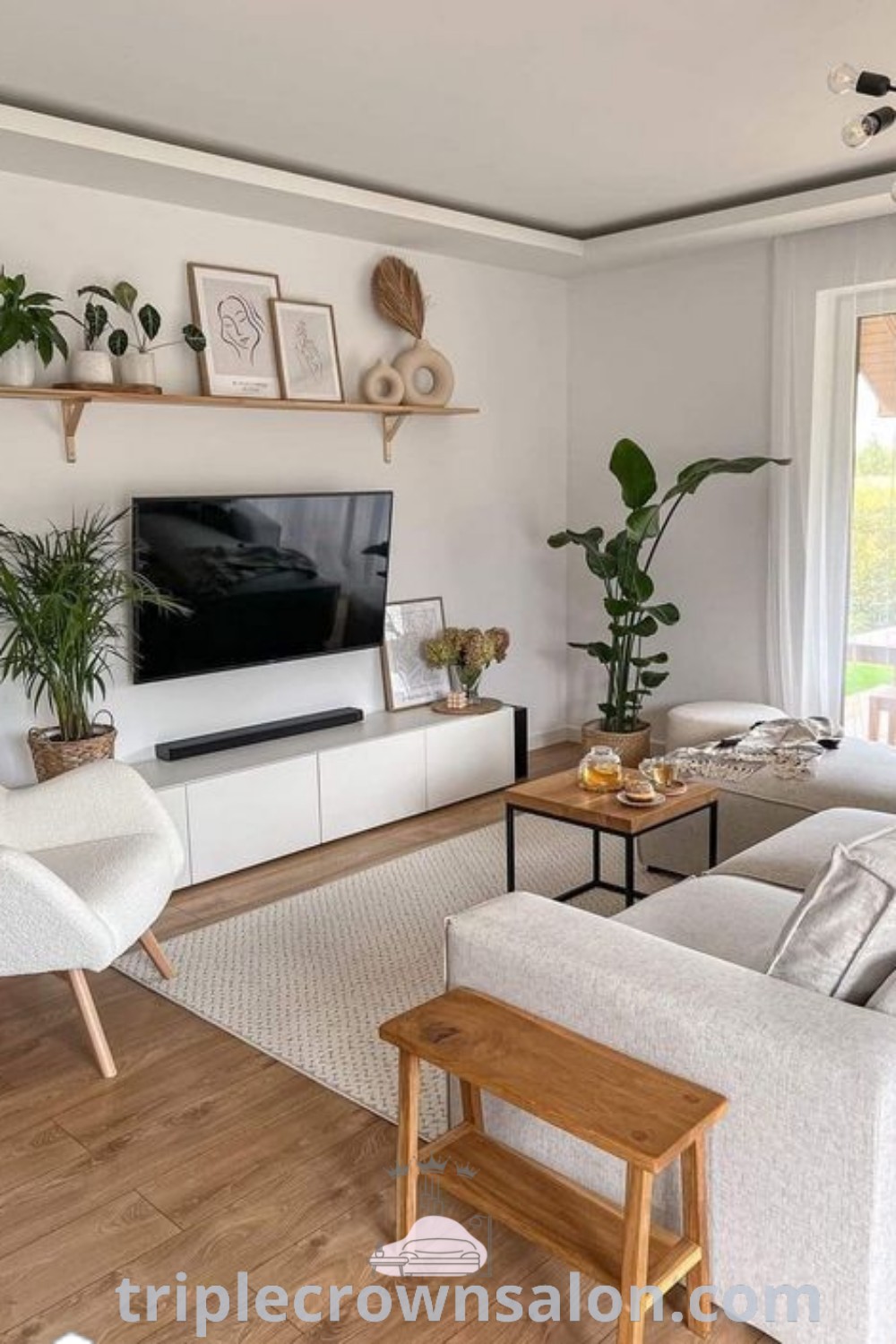 A stylish living room filled with cozy furniture, a flat screen TV mounted on the wall next to a window, showcasing a cozy aesthetic perfect for home inspiration. Explore unique decor ideas at triplecrownsalon.com.
