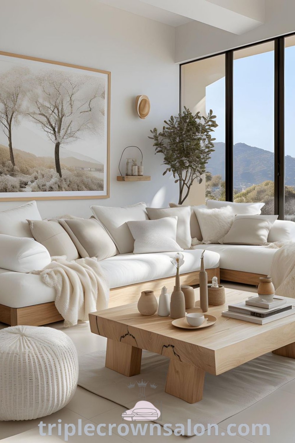 A beautiful living room showcasing white furniture and large windows, reflecting Japandi and Scandinavian design trends. The space features cozy decor ideas, perfect for a welcoming atmosphere. Explore inspiring ideas for your home at triplecrownsalon.com.