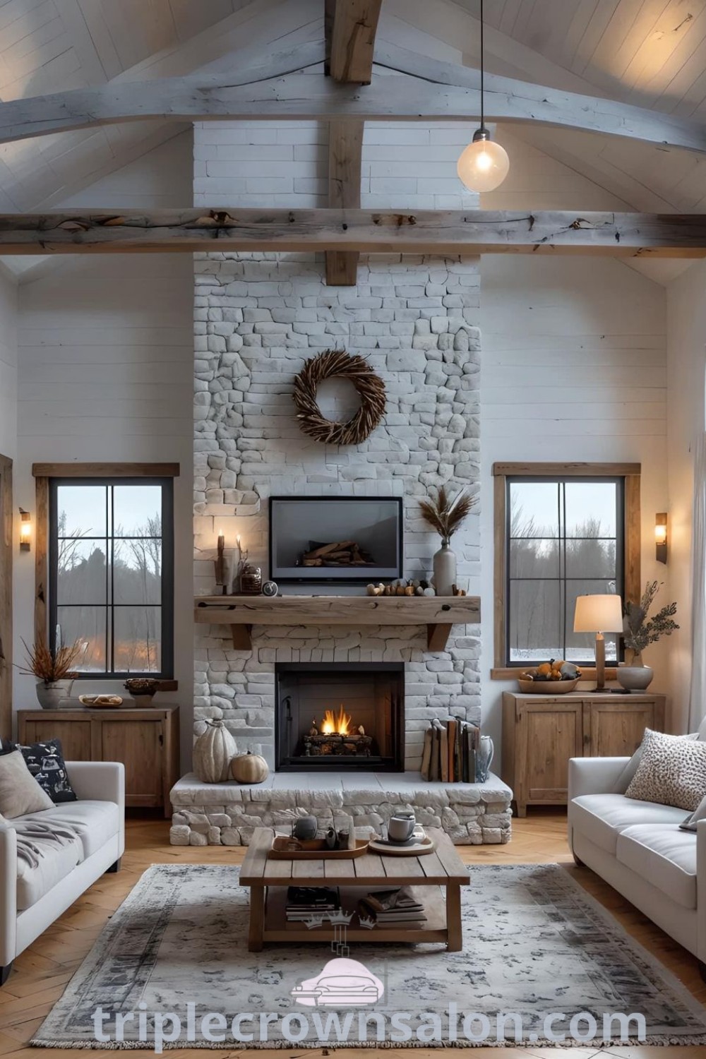 A cozy cathedral ceiling living room filled with stylish furniture, featuring a farmhouse fireplace as the focal point. The space combines modern home interior design with elements of Mediterranean style and barn-style house plans, offering inspiring decor ideas that enhance your home