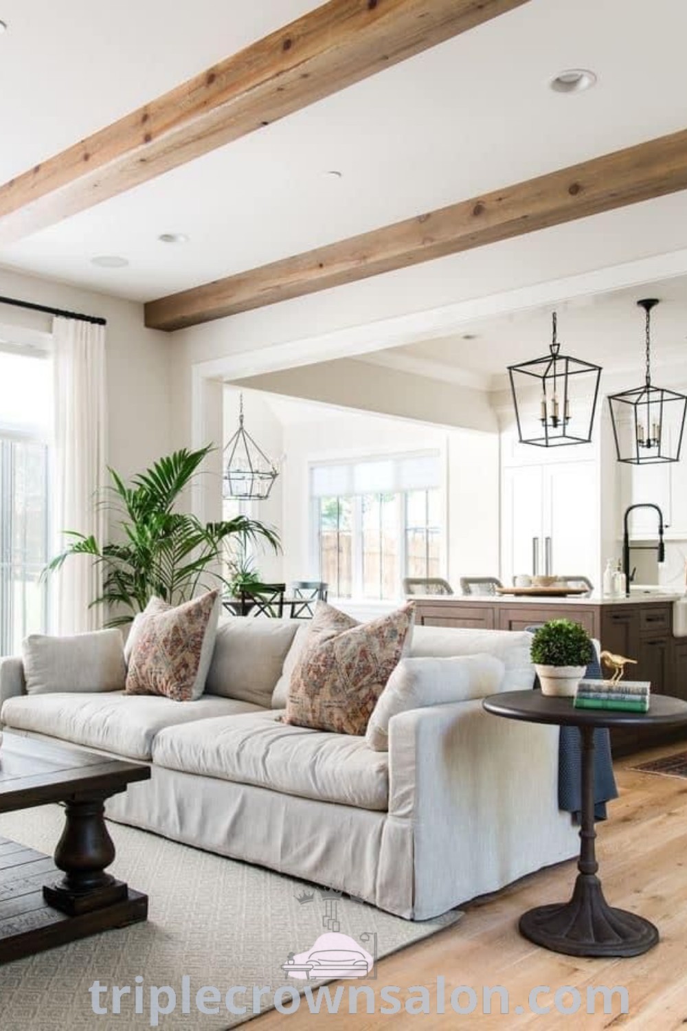 A cozy living room featuring modern wood beams on a non-vaulted ceiling, showcasing inspiring design ideas for enhancing open spaces with wood beam decor. Discover more about unique decor inspirations at triplecrownsalon.com.