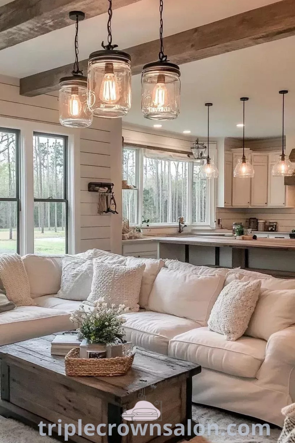 A spacious modern farmhouse living room featuring white furniture and plenty of lights hanging over the couches, showcasing cozy ideas and unique design inspirations for creating a warm home ambiance. Discover more decorating ideas for small spaces at triplecrownsalon.com.