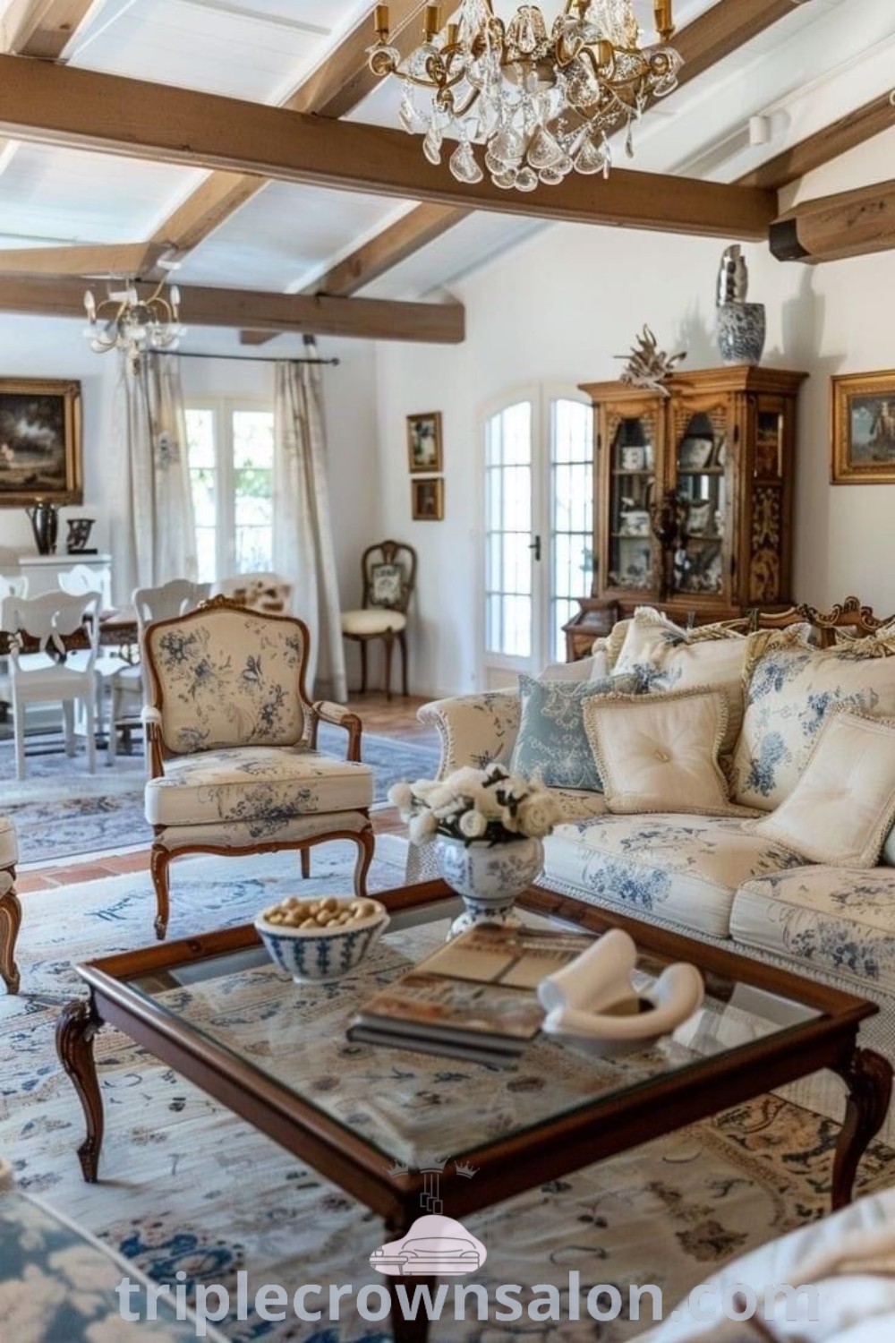 A cozy French country living room featuring rustic furniture and an elegant chandelier, embodying warmth and inviting aesthetics. This space serves as decor inspirations for a French Cottage Living Room, offering design ideas and unique inspirations for your home. Explore more at triplecrownsalon.com.