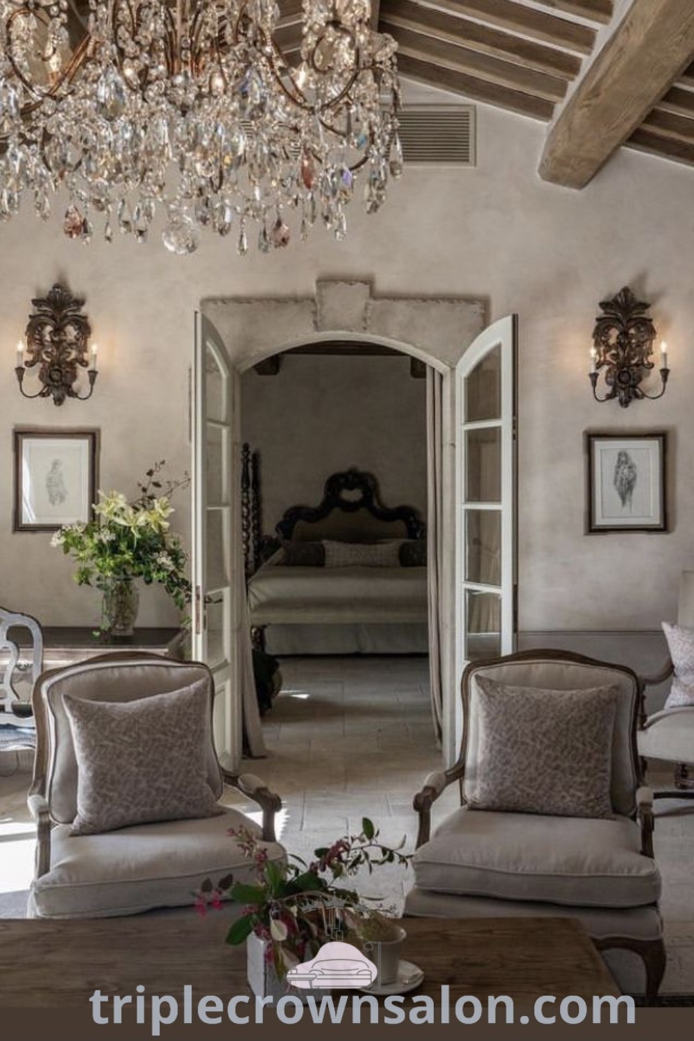 A cozy French Country living room filled with stylish furniture and a chandelier, offering decor ideas that inspire warmth and elegance. This inviting space exemplifies French Country interiors and features unique ideas for enhancing your home. Discover more inspirations at triplecrownsalon.com.