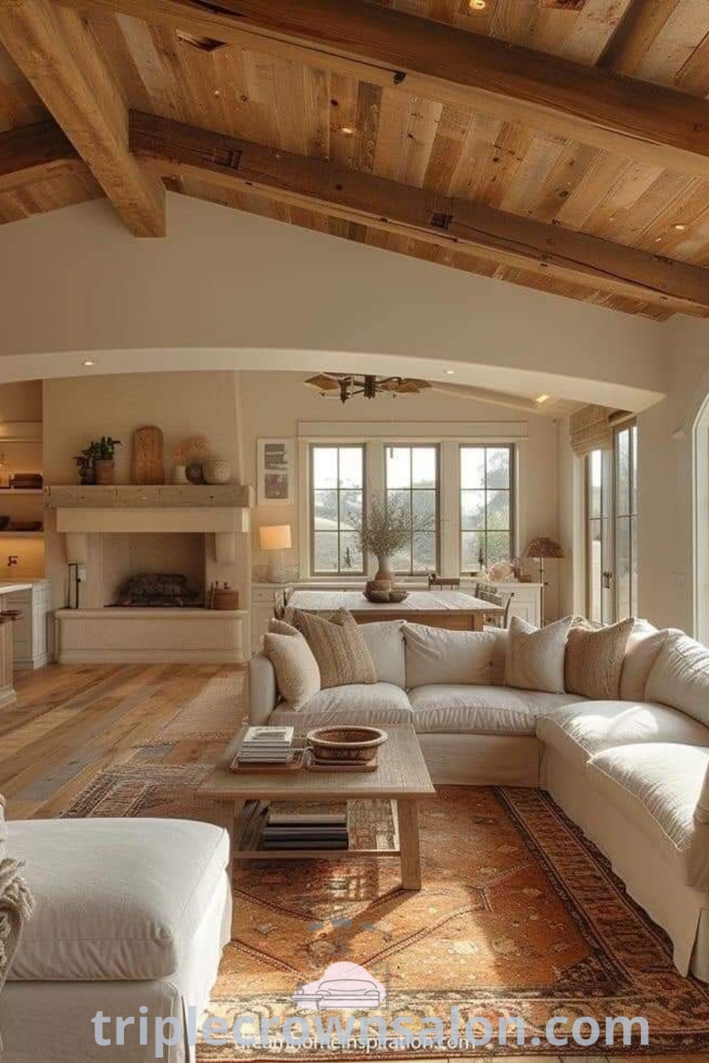 A modern farmhouse living room featuring white furniture and wooden ceiling beams, showcasing cozy decor ideas and design inspirations for a warm atmosphere. Discover more unique ideas for your home at triplecrownsalon.com.