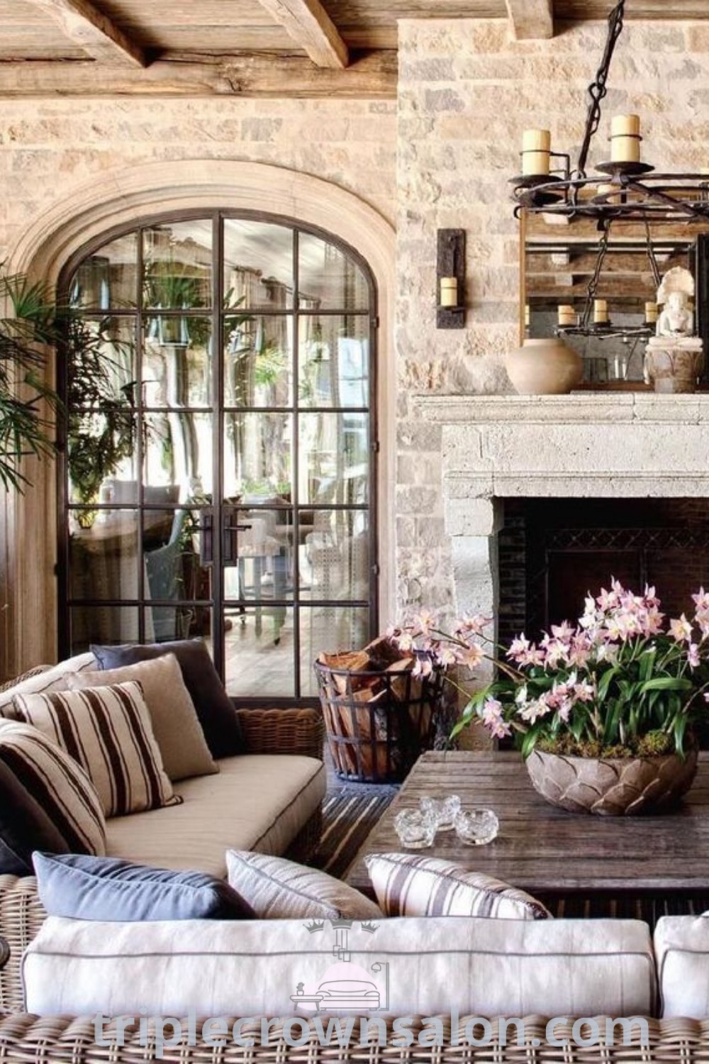 A charming European farmhouse living room filled with rustic furniture, a warm fireplace, and cozy decor ideas, offering unique inspiration for your home. This design showcases French country and Mediterranean styles, perfect for creating a welcoming ambiance. Explore more decor inspirations at triplecrownsalon.com.