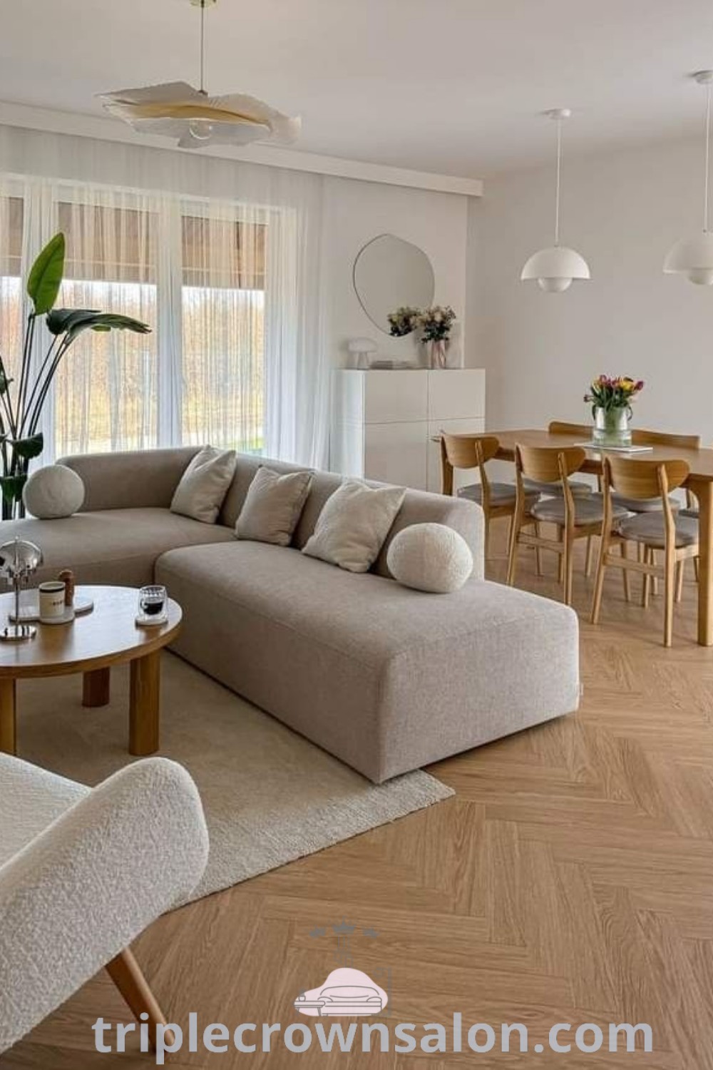A cozy open lounge room featuring modern furniture, a wooden table, and chairs on a hardwood floor. This space incorporates minimalist decor and modular sofa design ideas that inspire comfort and functionality. Discover more decor ideas and inspirations for your home at triplecrownsalon.com.