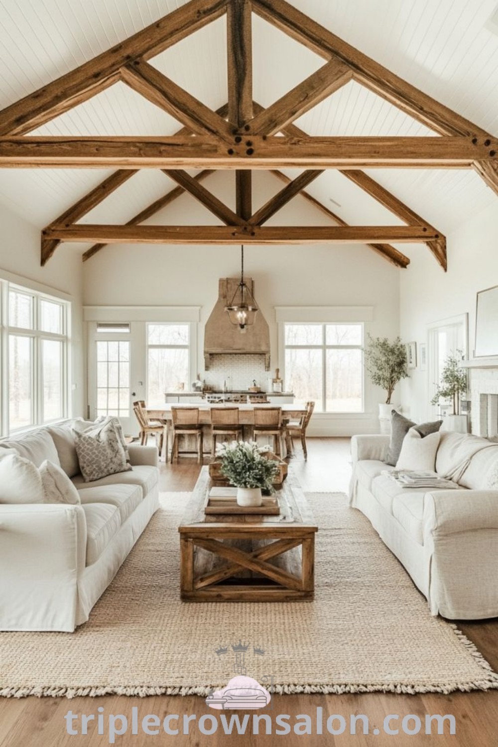A cozy farmhouse living room with a central fireplace, wooden beams, and comfortable furnishings, showcasing design ideas that blend style and functionality. This inviting space offers decor inspirations for creating a cozy home. Explore more unique ideas and decorating tips at triplecrownsalon.com.