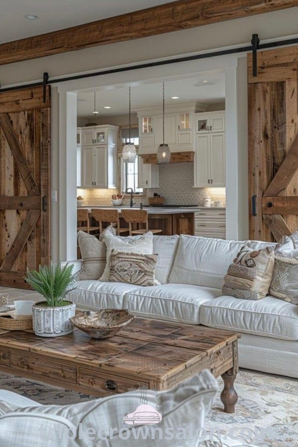 A cozy country living room featuring white couches, wooden sliding doors to a kitchen, and rugs for added warmth. This inviting space highlights decor ideas for small spaces, blending farmhouse aesthetics with modern country style. Find more inspiring ideas for your home at triplecrownsalon.com.