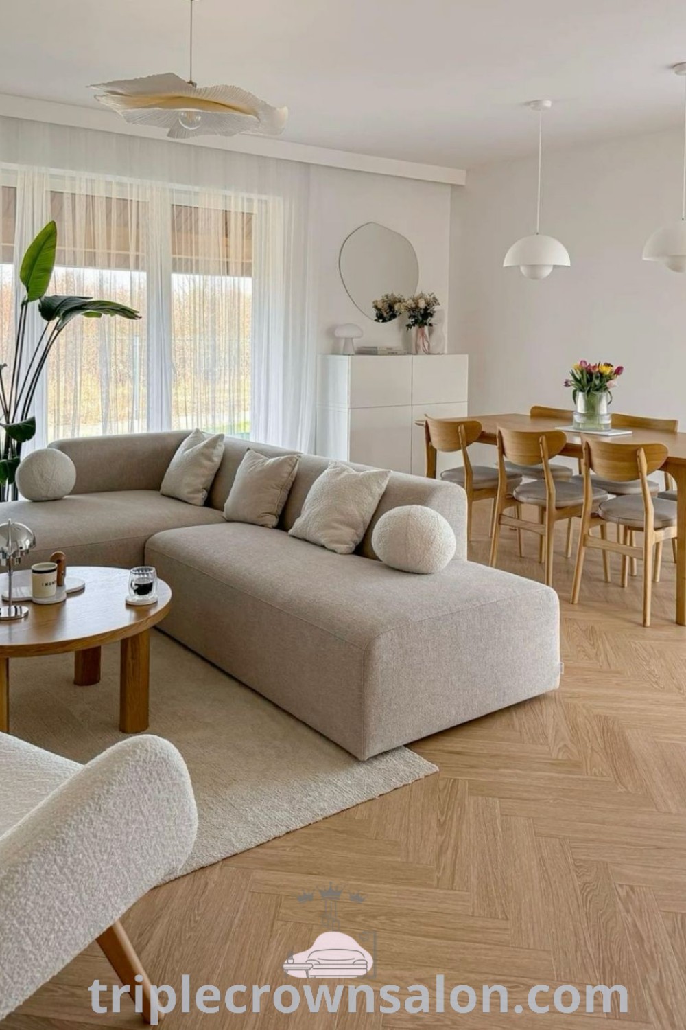 A modern black and white living room showcasing a chic corner sofa, wooden floor, and inspiring wall art. This decor illustrates cozy home design ideas, perfect for apartment hunting or small spaces, emphasizing unique ideas for stylish living. Discover more design tips at triplecrownsalon.com.
