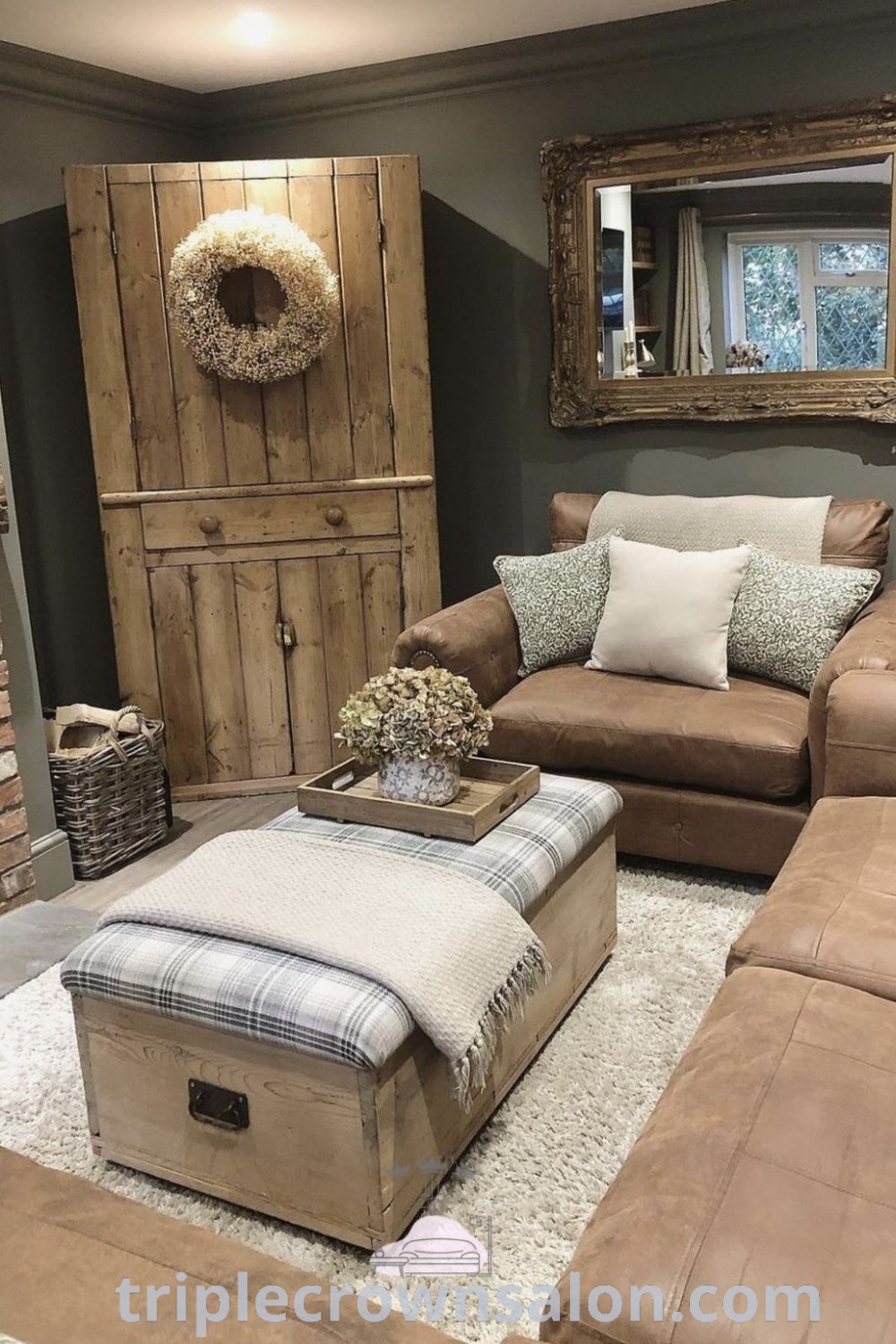 A cozy brown neutral living room featuring a large mirror above the fireplace, a brown couch, and inviting decor inspirations. Discover brown couch living room ideas and design tips for your home at triplecrownsalon.com.
