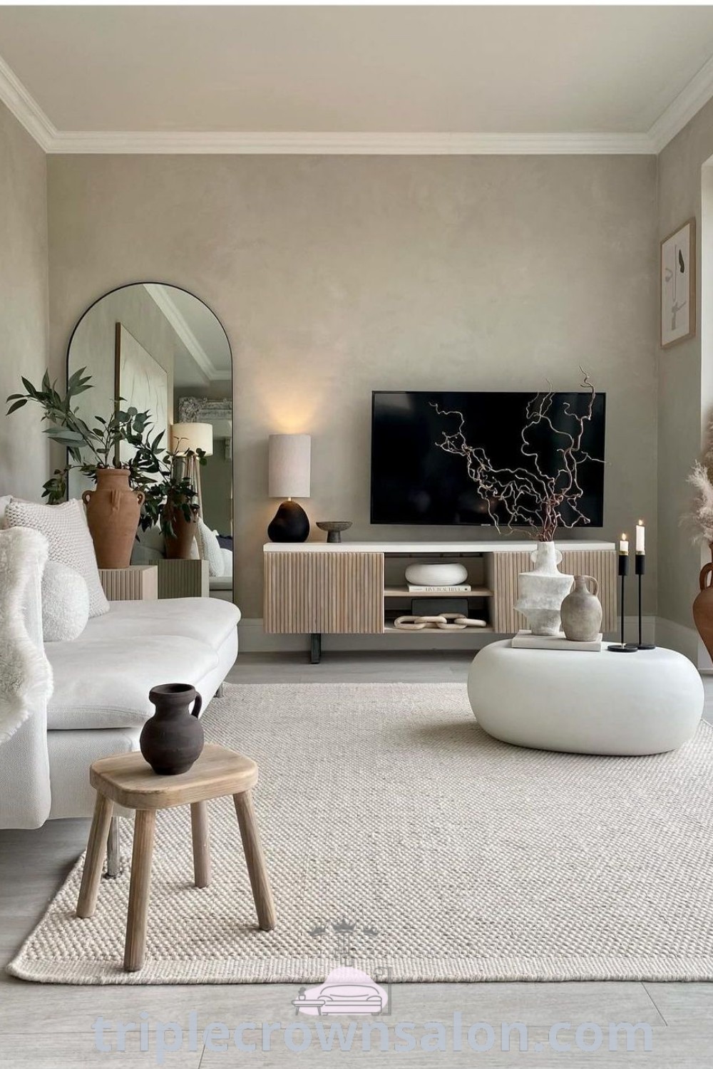 A modern minimalist living room showcasing grey flooring, a flat-screen TV mounted on the wall, and stylish furniture. This space offers unique decor ideas for small spaces, combining cozy aesthetics with functional TV wall decor concepts. Explore inspiring design tips at triplecrownsalon.com.