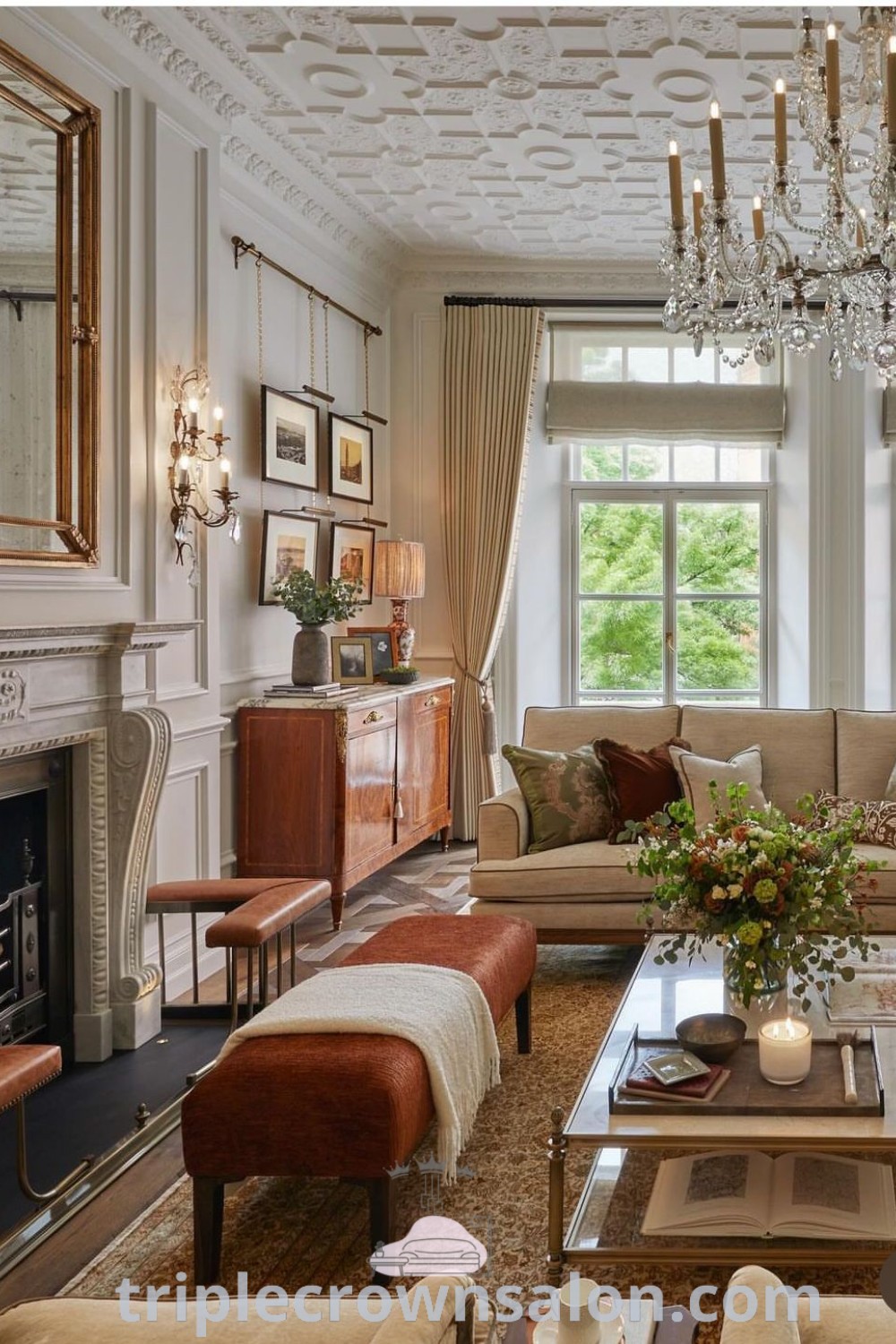 An elegant Arizona living room featuring a dark blue couch, tasteful furniture arrangement, and a chandelier, embodying classic interior design elements. This decor offers cozy ideas and design inspirations that elevate any house or apartment. Find more inspiring decor ideas at triplecrownsalon.com.