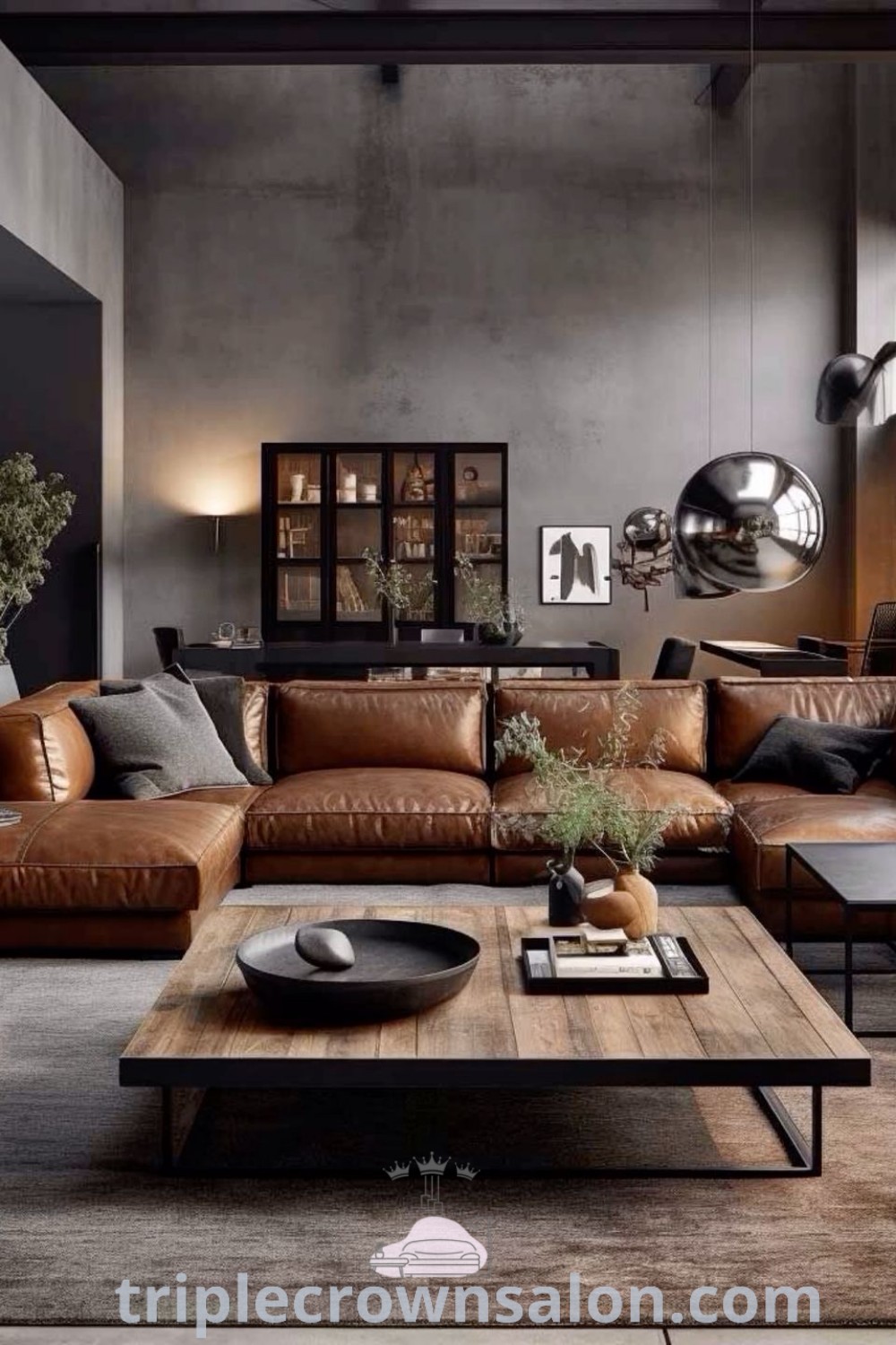 A cozy living room decorated with a brown leather couch and industrial accents, featuring large windows and framed views. This inspiring design offers decor ideas for small spaces, blending rustic and industrial elements seamlessly. Discover more unique ideas for your home at triplecrownsalon.com.